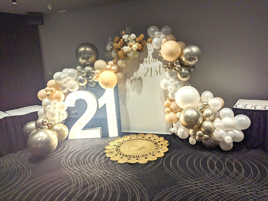 Illuminated '21' with a gold, white, and silver balloon arch, white backdrop, and floral arrangement. Prop hire, Prop hiring, Prop hire, event stylists Brisbane, brisbane event styling, brisbane event styling, event stylist Brisbane, Brisbane Wedding, Gold Coast Wedding, Floral Styling, Lush & Lavish Events, Brisbane Tablescape, Gold Coast Tablescapes, Brisbane Candle Hire