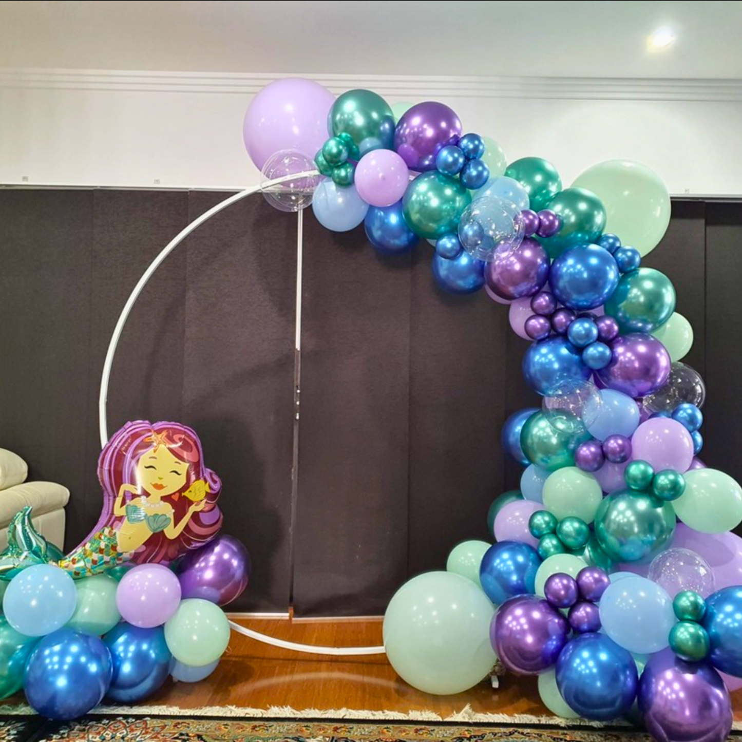Colorful balloon arch with a mermaid figure at the bottom left, set against a dark background. Prop hire, Prop hiring, Prop hire, event stylists Brisbane, brisbane event styling, brisbane event styling, event stylist Brisbane, Brisbane Wedding, Gold Coast Wedding, Floral Styling, Lush & Lavish Events, Brisbane Tablescape, Gold Coast Tablescapes, Brisbane Candle Hire