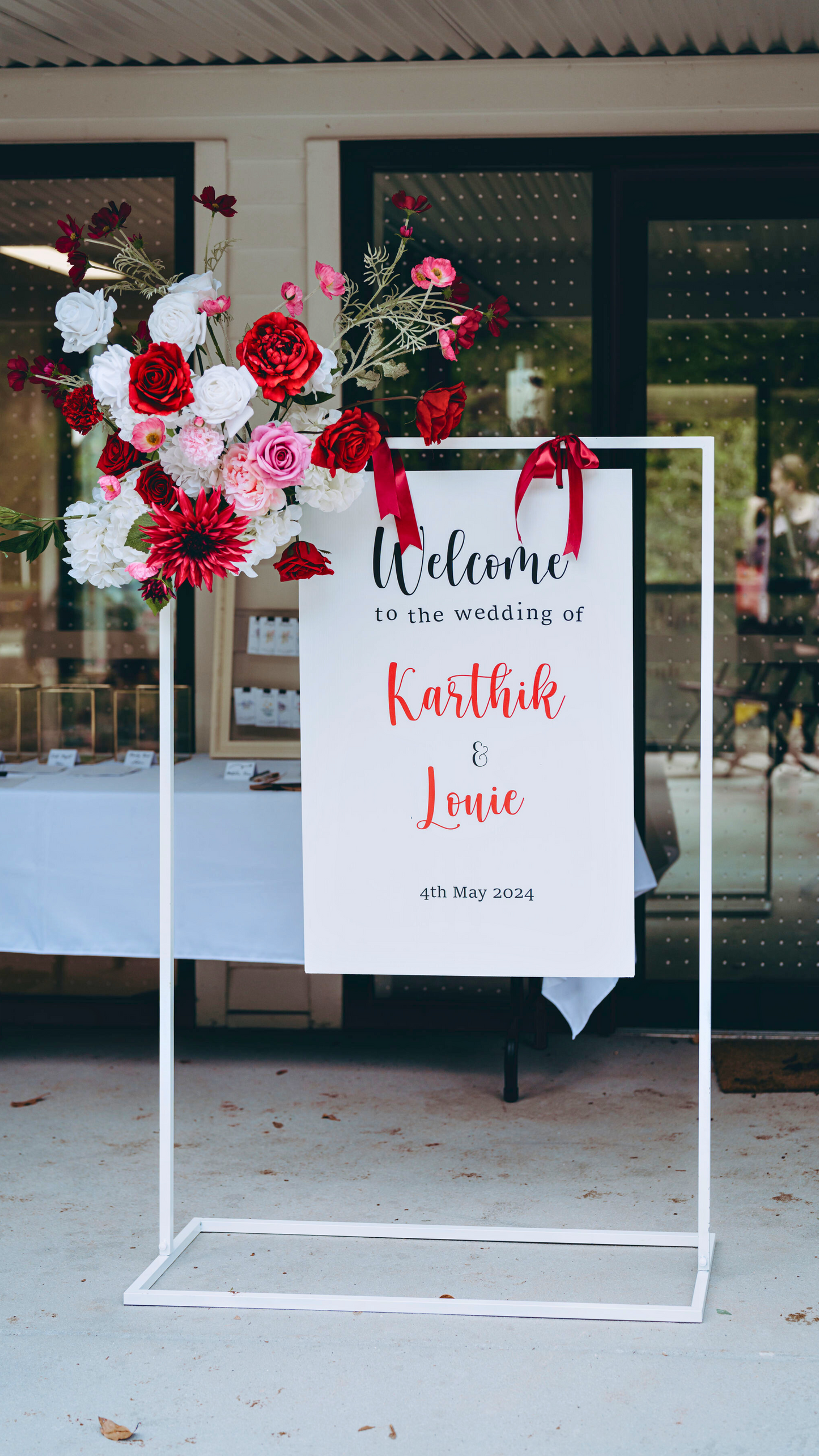 Wedding welcome sign with floral decorations, reading: "Welcome to the wedding of Karthik & Louie, 4th May 2024. Prop hire, Prop hiring, Prop hire, event stylists Brisbane, brisbane event styling, brisbane event styling, event stylist Brisbane, Brisbane Wedding, Gold Coast Wedding, Floral Styling, Lush & Lavish Events, Brisbane Tablescape, Gold Coast Tablescapes, Brisbane Candle Hire