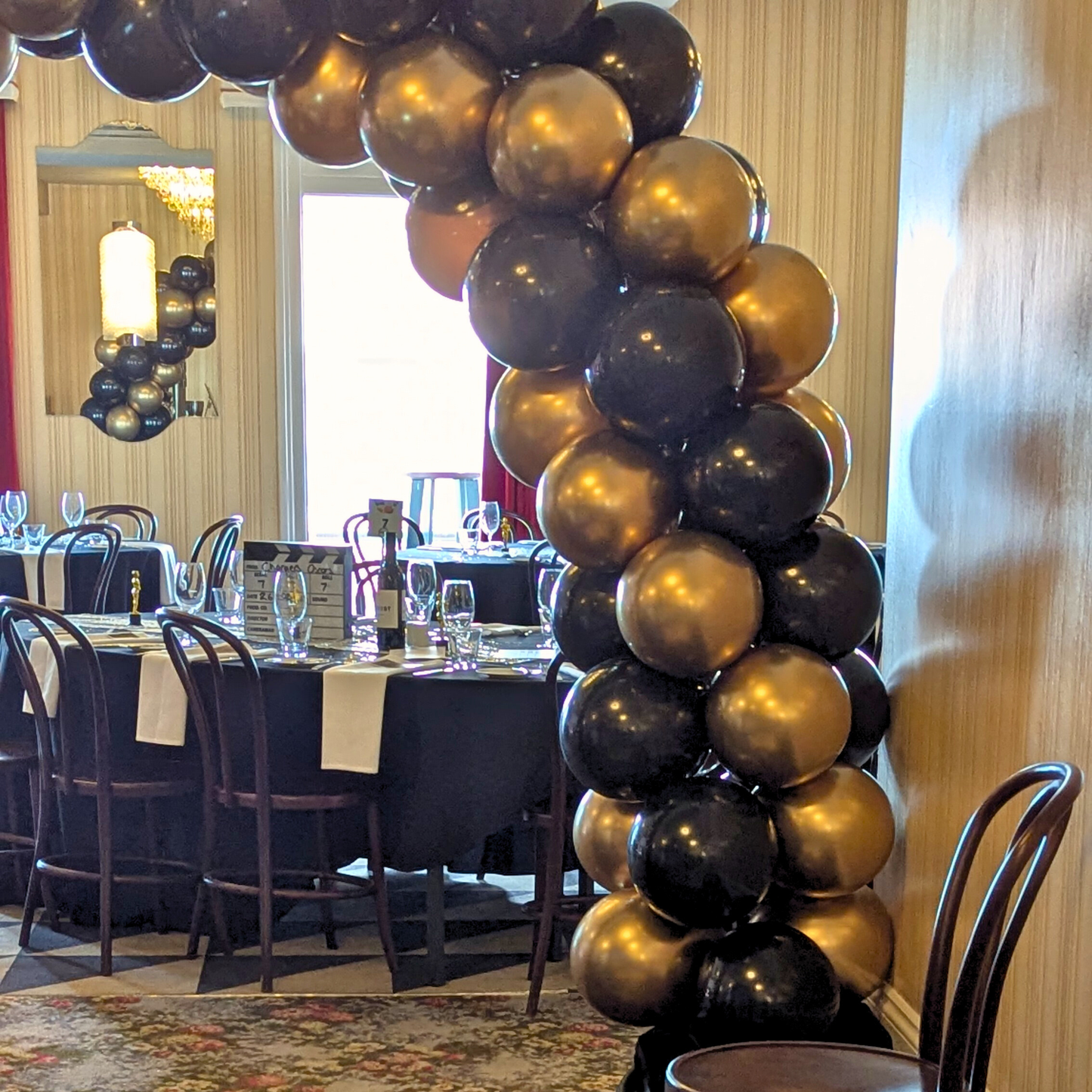 Balloon arch made of black and gold balloons in a banquet hall. corporate balloon arch Brisbane, branded balloon arch QLD, corporate event styling Brisbane, balloon arch for product launch, brand activation balloon display, media wall balloon arch Brisbane, conference balloon styling QLD, corporate event balloons Gold Coast, custom colour balloon arch Brisbane, business event balloon installation QLD