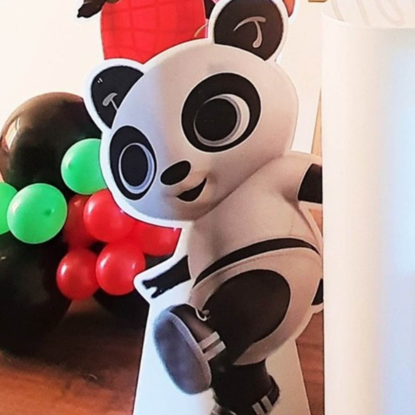 panda toy with a cheerful expression, set against a vibrant backdrop of red, green, and black balloons, perfect for children’s party decorations and festive event styling. Prop hire, Prop hiring, Prop hire, event stylists Brisbane, brisbane event styling, brisbane event styling, event stylist Brisbane, Brisbane Wedding, Gold Coast Wedding, Floral Styling, Lush & Lavish Events