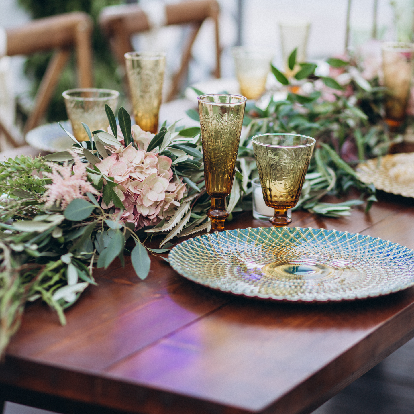 Dining table with ornate glass plates, amber goblets, lush greenery, and pink floral centerpiece. Prop hire, Prop hiring, Prop hire, event stylists Brisbane, brisbane event styling, brisbane event styling, event stylist Brisbane, Brisbane Wedding, Gold Coast Wedding, Floral Styling, Lush & Lavish Events, Brisbane Tablescape, Gold Coast Tablescapes, Brisbane Candle Hire