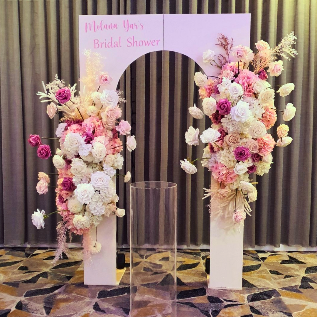 Bridal shower setup with an arch reading ‘Mikaela Yeo’s Bridal Shower’ adorned with pink, white, and peach floral arrangements on white pedestals against a gray backdrop. Prop hire, Prop hiring, Prop hire, event stylists Brisbane, brisbane event styling, brisbane event styling, event stylist Brisbane, Brisbane Wedding, Gold Coast Wedding, Floral Styling, Lush & Lavish Events, Brisbane Tablescape, Gold Coast Tablescapes, Brisbane Candle Hire