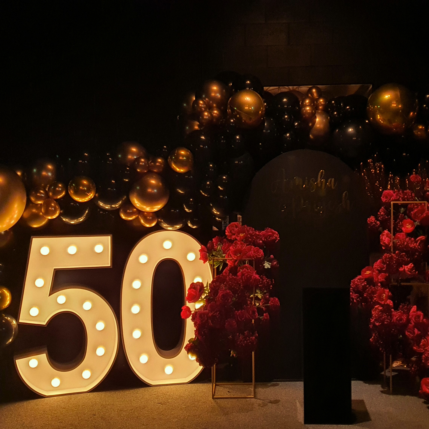 Large '50' with light bulbs, golden and black balloons, red flower archway, and 'Amish and Priyesh' sign. Prop hire, Prop hiring, Prop hire, event stylists Brisbane, brisbane event styling, brisbane event styling, event stylist Brisbane, Brisbane Wedding, Gold Coast Wedding, Floral Styling, Lush & Lavish Events, Brisbane Tablescape, Gold Coast Tablescapes, Brisbane Candle Hire