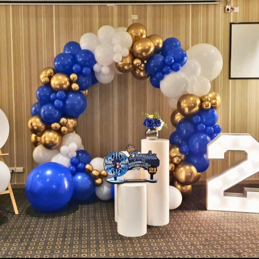 Large white numerals '2' and '1' with a blue, gold, and white balloon arch, and a transparent award reading 'Congratulations Class of 2021' on two small plinths. Prop hire, Prop hiring, Prop hire, event stylists Brisbane, brisbane event styling, brisbane event styling, event stylist Brisbane, Brisbane Wedding, Gold Coast Wedding, Floral Styling, Lush & Lavish Events, Brisbane Tablescape, Gold Coast Tablescapes, Brisbane Candle Hire