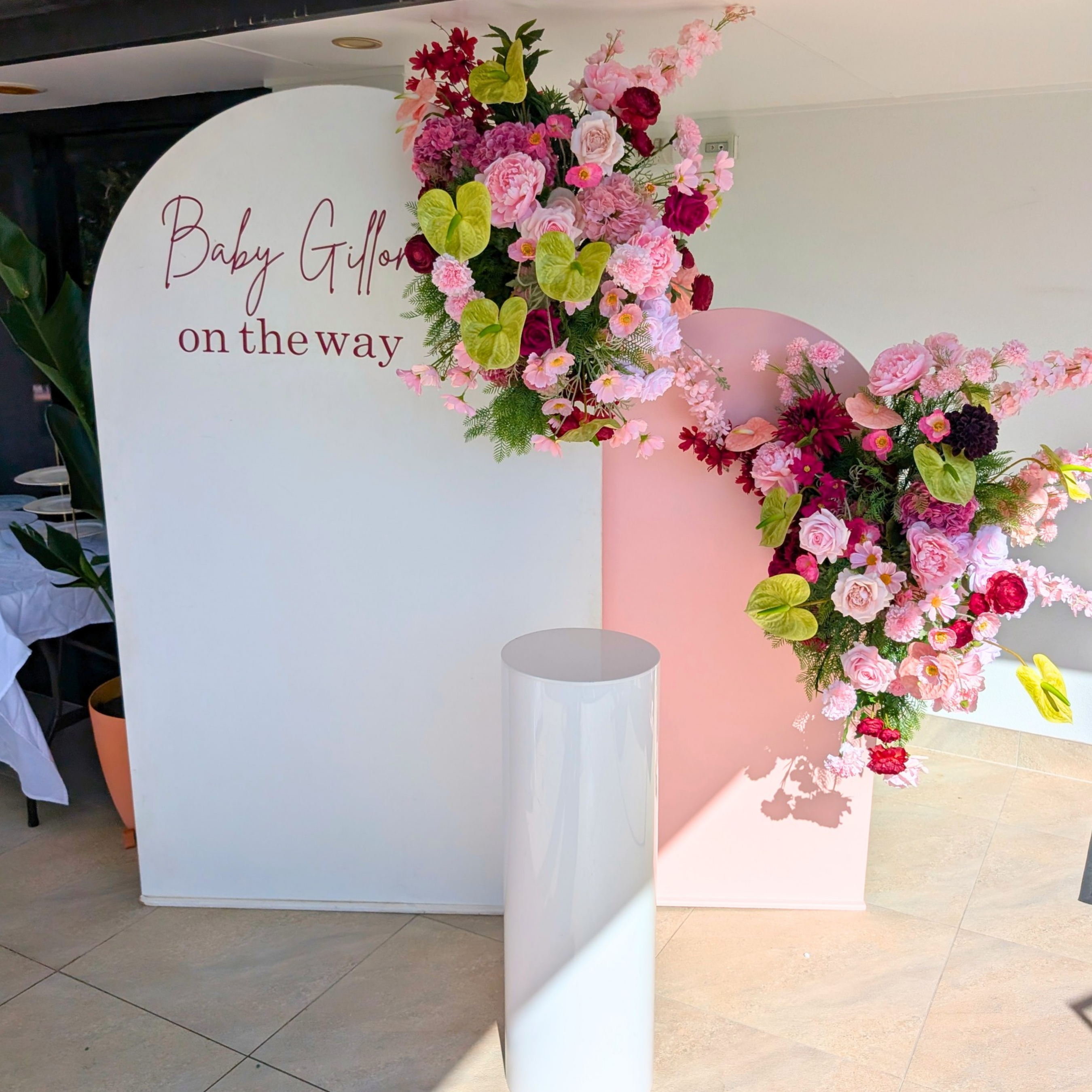 Burgundy and green baby shower floral backdrop featuring elegant artificial flowers, lush greenery and a stylish celebration design. Perfect for luxury baby showers, gender reveals, welcome baby events and event styling in Brisbane, Gold Coast and South East Queensland.