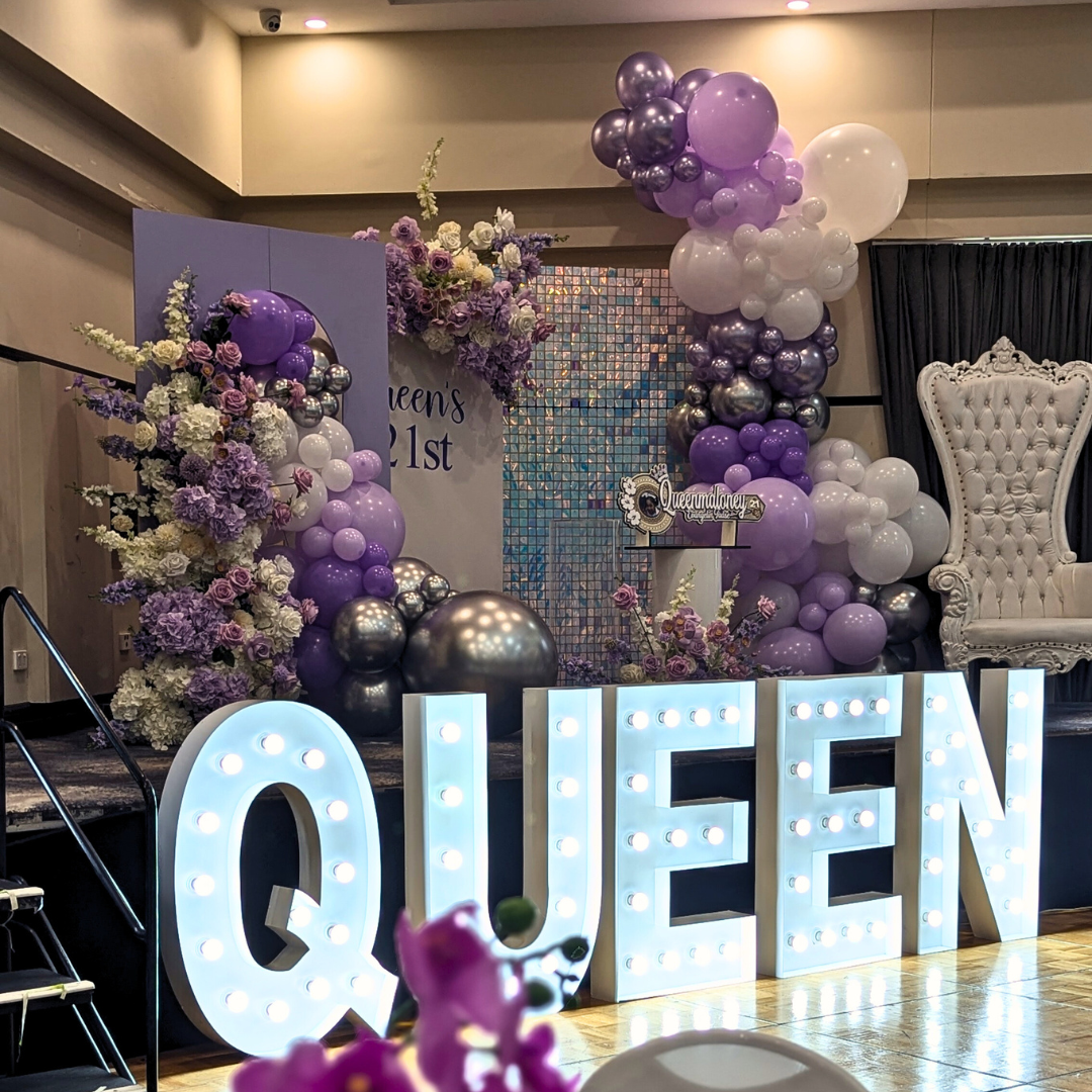Purple, white silver floral and balloon backdrop with an iridescent shimmer wall. Signage says "Queen's 21st" with large LED lights. Prop hire, Prop hiring, Prop hire, event stylists Brisbane, brisbane event styling, brisbane event styling, event stylist Brisbane, Brisbane Wedding, Gold Coast Wedding, Floral Styling, Lush & Lavish Events, Brisbane Corporate Styling, Gold Coast Corporate Styling, Brisbane Brand Activation, Gold Coast Tablescapes, Brisbane Candle Hire