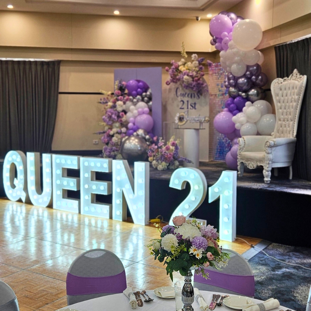 Purple, white silver floral and balloon backdrop with an iridescent shimmer wall. Signage says "Queen's 21st" with large LED lights. Prop hire, Prop hiring, Prop hire, event stylists Brisbane, brisbane event styling, brisbane event styling, event stylist Brisbane, Brisbane Wedding, Gold Coast Wedding, Floral Styling, Lush & Lavish Events, Brisbane Corporate Styling, Gold Coast Corporate Styling, Brisbane Brand Activation, Gold Coast Tablescapes, Brisbane Candle Hire