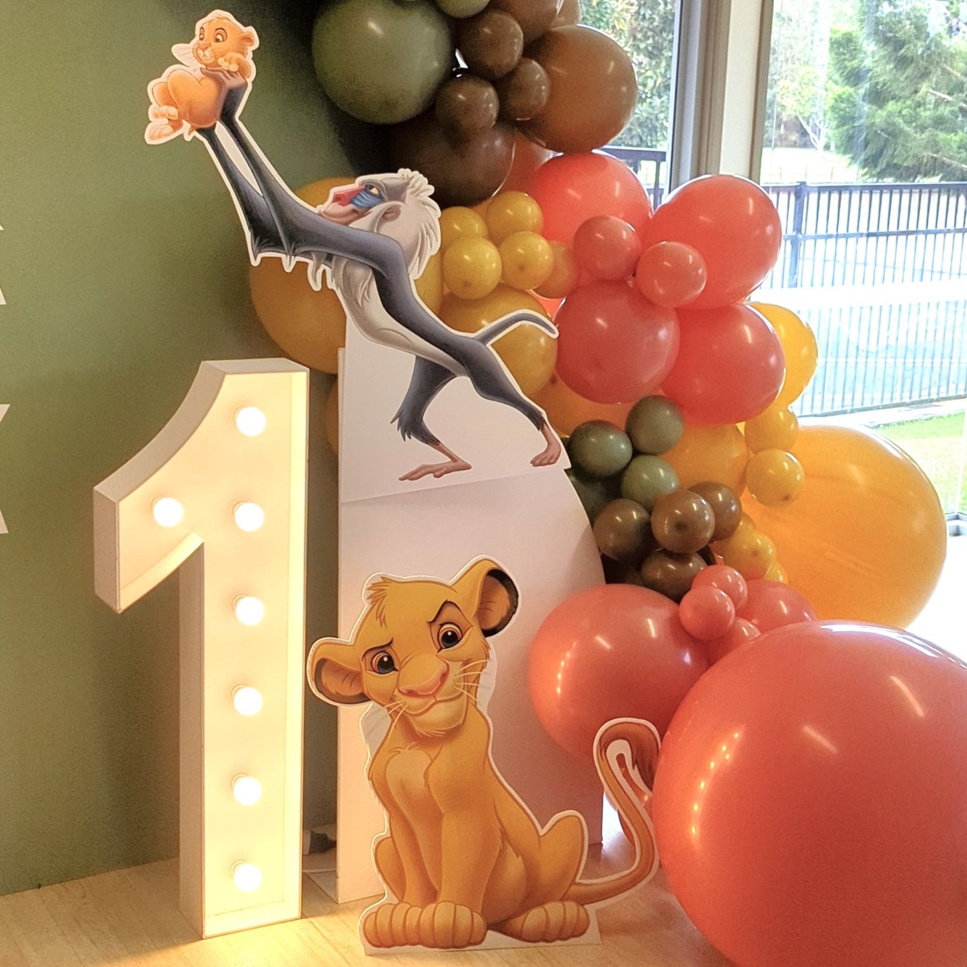 First birthday setup with Lion King characters, illuminated '1,' and colorful balloons. Prop hire, Prop hiring, Prop hire, event stylists Brisbane, brisbane event styling, brisbane event styling, event stylist Brisbane, Brisbane Wedding, Gold Coast Wedding, Floral Styling, Lush & Lavish Events, Brisbane Tablescape, Gold Coast Tablescapes, Brisbane Candle Hire