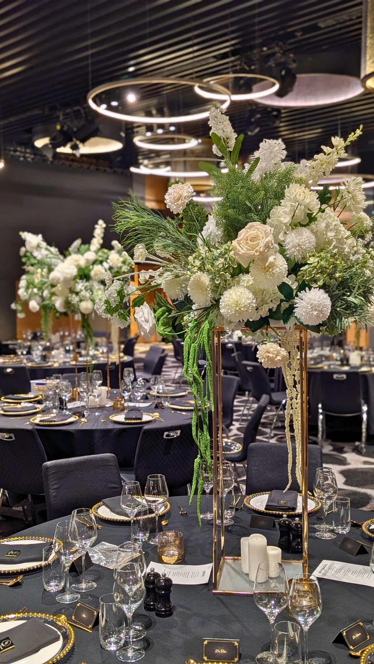 Decorative table setting with floral arrangements and fine diningware in a formal dining room. tall floral centrepieces Brisbane, wedding centrepieces hire Brisbane, gold stand centrepieces Australia, tall wedding centrepieces QLD, floral plinth centrepiece hire, luxe wedding centrepieces Australia, event centrepiece hire Gold Coast, tall table centrepieces Brisbane, custom floral centrepieces QLD, wedding table styling Brisbane, elegant centrepieces Sunshine Coast, large floral centrepieces Australia