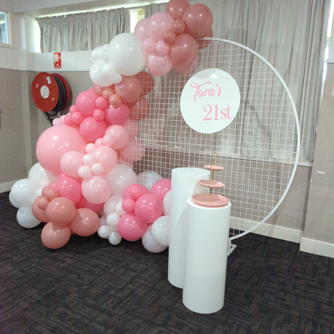 Balloon arch with pink and white balloons and a sign reading 'Tara's 21st'.  Prop hire, Prop hiring, Prop hire, event stylists Brisbane, brisbane event styling, brisbane event styling, event stylist Brisbane, Brisbane Wedding, Gold Coast Wedding, Floral Styling, Lush & Lavish Events, Brisbane Corporate Styling, Gold Coast Corporate Styling, Brisbane Brand Activation, Gold Coast Tablescapes, Brisbane Candle Hire
 in a room.