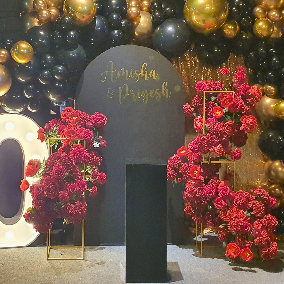 Decorative setup with flowers, balloons, and signage saying Amisha & Priyesh 50th milestone birthday backdrop. Prop hire, Prop hiring, Prop hire, event stylists Brisbane, brisbane event styling, brisbane event styling, event stylist Brisbane, Brisbane Wedding, Gold Coast Wedding, Floral Styling, Lush & Lavish Events, Brisbane Corporate Styling, Gold Coast Corporate Styling, Brisbane Brand Activation, Gold Coast Tablescapes, Brisbane Candle Hire