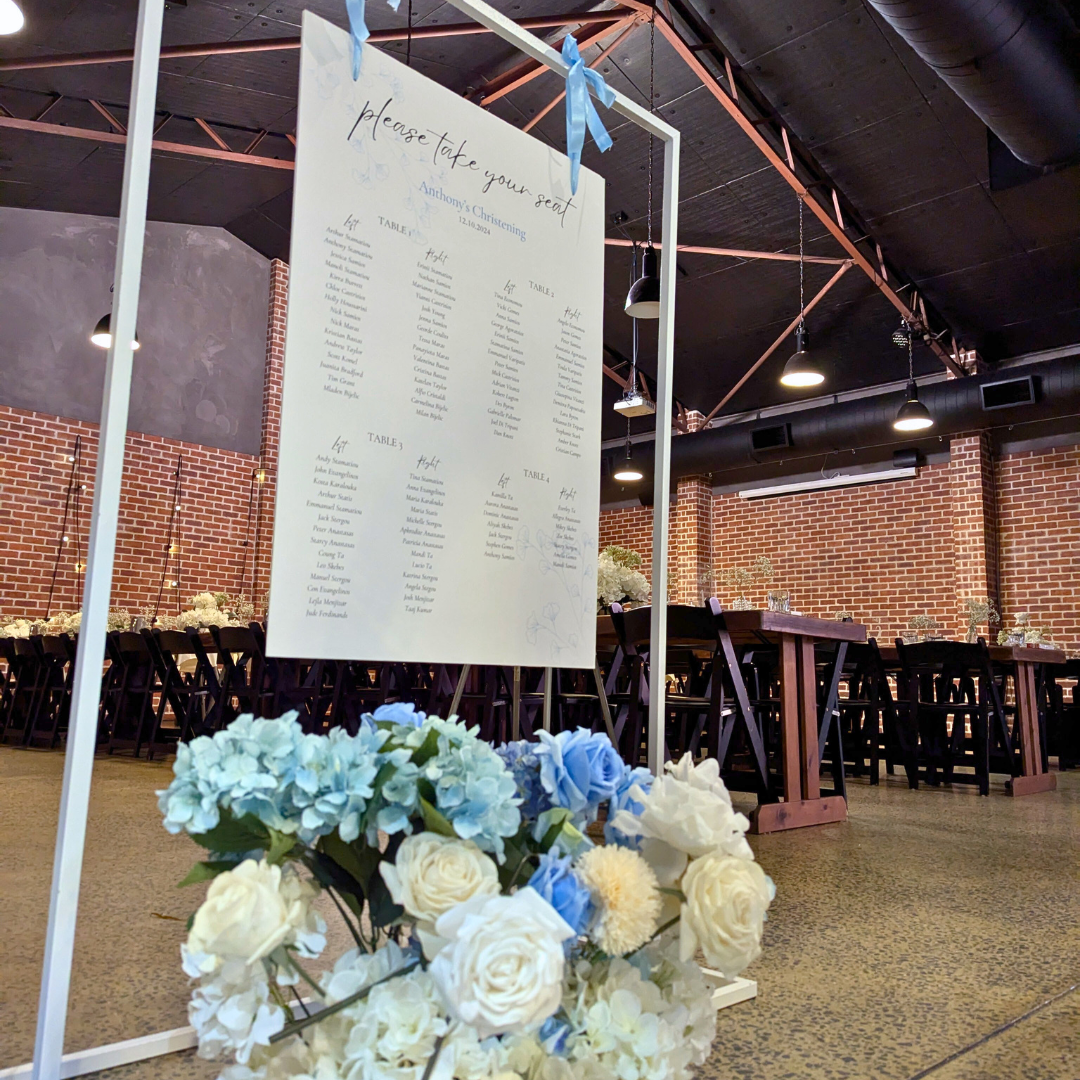 blue white floral and balloon backdrop woth wording "Anthony's Christening" . PErsonalised menus with guest name on, baby breath bud vases and white floral domes. Personalised custom seating chart and floral arrangement. Prop hire, Prop hiring, Prop hire, event stylists Brisbane, brisbane event styling, brisbane event styling, event stylist Brisbane, Brisbane Wedding, Gold Coast Wedding, Floral Styling, Lush & Lavish Events, Brisbane Corporate Styling, Gold Coast Tablescapes, Brisbane Candle Hire
