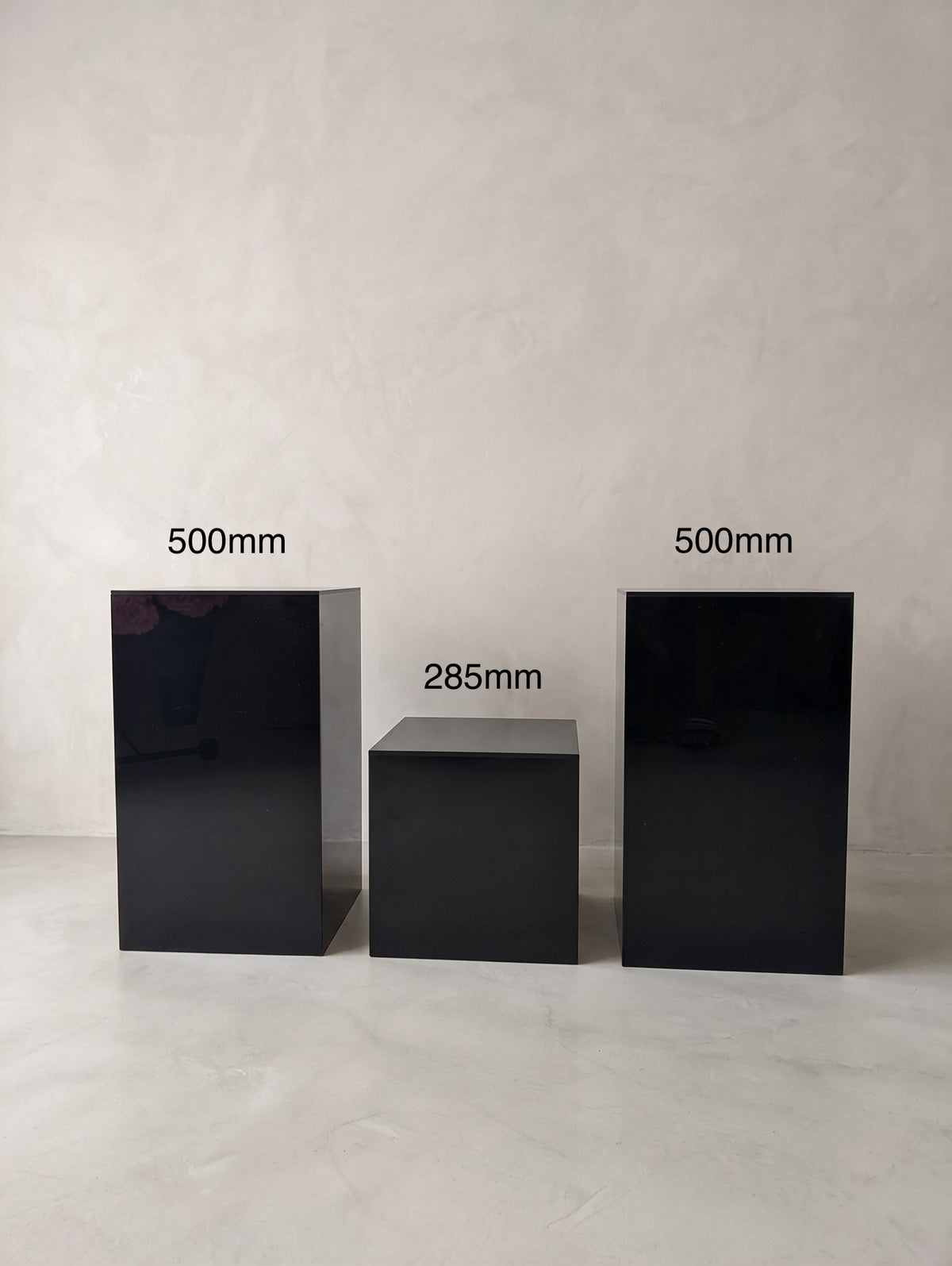 Two 500 mm glossy black rectangular plinths beside a 285 mm cube plinth.