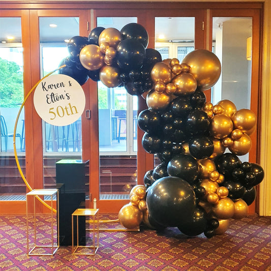 Black and gold round balloon arch at venue entrance for milestone celebrations. Prop hire, Prop hiring, Prop hire, event stylists Brisbane, brisbane event styling, brisbane event styling, event stylist Brisbane, Brisbane Wedding, Gold Coast Wedding, Floral Styling, Lush & Lavish Events, Brisbane Tablescape, Gold Coast Tablescapes, Brisbane Candle Hire