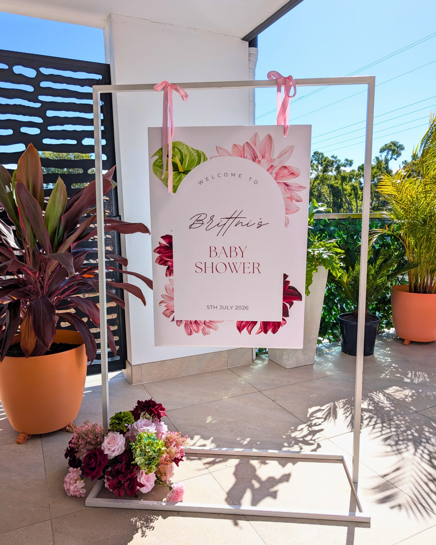 Large frame welcome sign hire featuring a personalised A4 poster displayed on a white metal frame with elegant ribbons and a complementary floral arrangement. Perfect for weddings, engagement parties, baby showers, milestone birthdays, 18th and 21st birthday celebrations, kids parties and luxury event styling in Brisbane, Gold Coast and South East Queensland.
