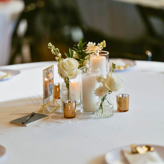 Table setting with candles and flowers on a white tablecloth. reception table styling hire, guest table décor hire, wedding table decoration hire, faux bud vases hire, wedding flower décor hire, elegant table styling hire, wedding table centrepieces hire, Brisbane wedding décor hire, Gold Coast wedding décor hire, DIY wedding table styling, DIY reception table décor, DIY wedding centrepieces, DIY faux flower table styling, DIY wedding vases set, DIY wedding table décor Brisbane, DIY wedding table décor Gold