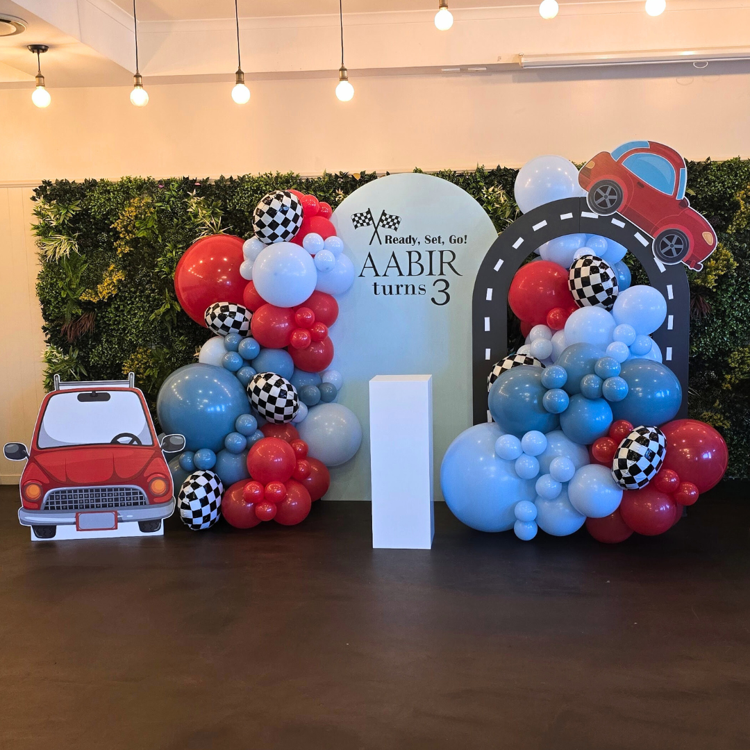 Balloon backdrop in blues, red and checkered foil balloons. Cars theme backdrop with signage "Ready, Set, Go! Aabir turns 3". Prop hire, Prop hiring, Prop hire, event stylists Brisbane, brisbane event styling, brisbane event styling, event stylist Brisbane, Brisbane Wedding, Gold Coast Wedding, Floral Styling, Lush & Lavish Events, Brisbane Corporate Styling, Gold Coast Corporate Styling, Brisbane Brand Activation, Gold Coast Tablescapes, Brisbane Candle Hire