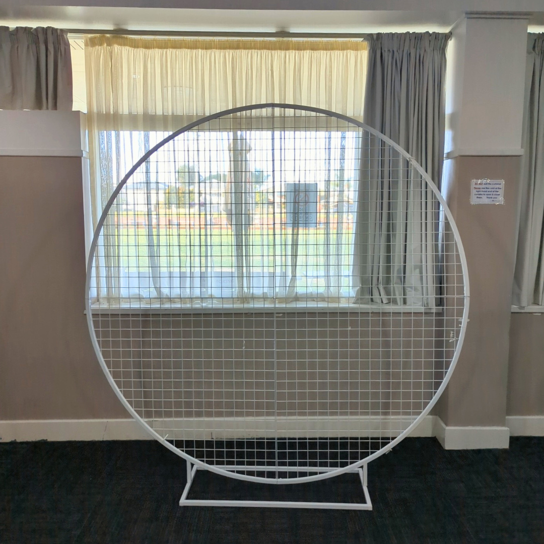 Circular metal white mesh arch in a room with curtains and a window.  Prop hire, Prop hiring, Prop hire, event stylists Brisbane, brisbane event styling, brisbane event styling, event stylist Brisbane, Brisbane Wedding, Gold Coast Wedding, Floral Styling, Lush & Lavish Events, Brisbane Corporate Styling, Gold Coast Corporate Styling, Brisbane Brand Activation, Gold Coast Tablescapes, Brisbane Candle Hire
