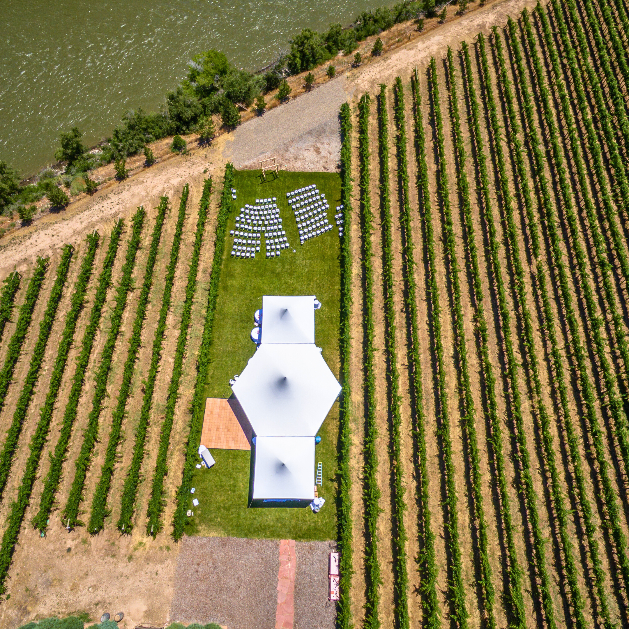 Vineyard with white tents and chairs set up for an event, near a river. Prop hire, Prop hiring, Prop hire, event stylists Brisbane, brisbane event styling, brisbane event styling, event stylist Brisbane, Brisbane Wedding, Gold Coast Wedding, Floral Styling, Lush & Lavish Events, Brisbane Corporate Styling, Gold Coast Corporate Styling, Brisbane Brand Activation