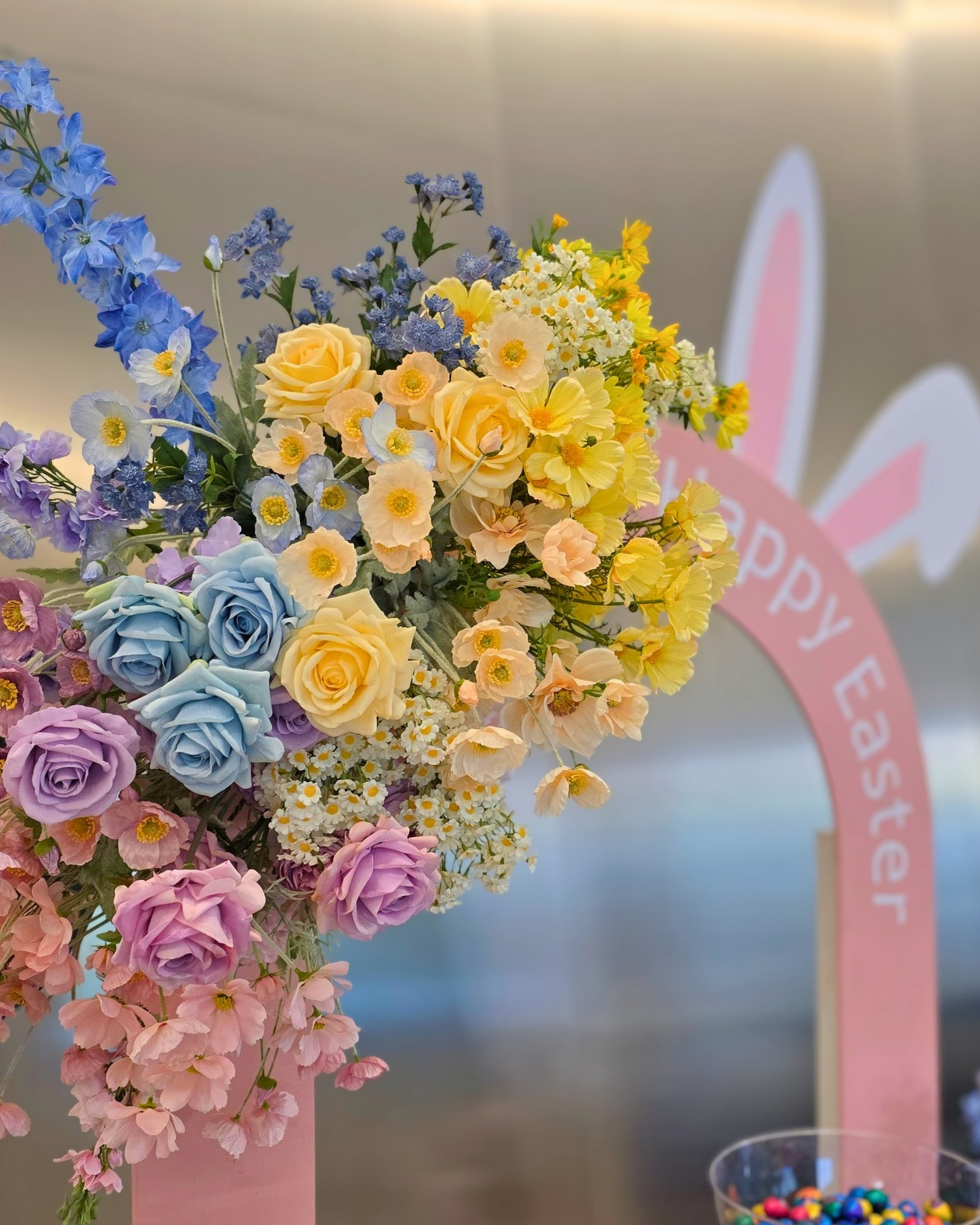 Easter themed brand activation backdrop featuring a hollow arch design with bunny ear cut out detail, oversized pastel floral arrangements and a stylish event display. Perfect for corporate Easter events, brand activations, retail installations, community events and promotional photo opportunities in Brisbane, Gold Coast and South East Queensland.