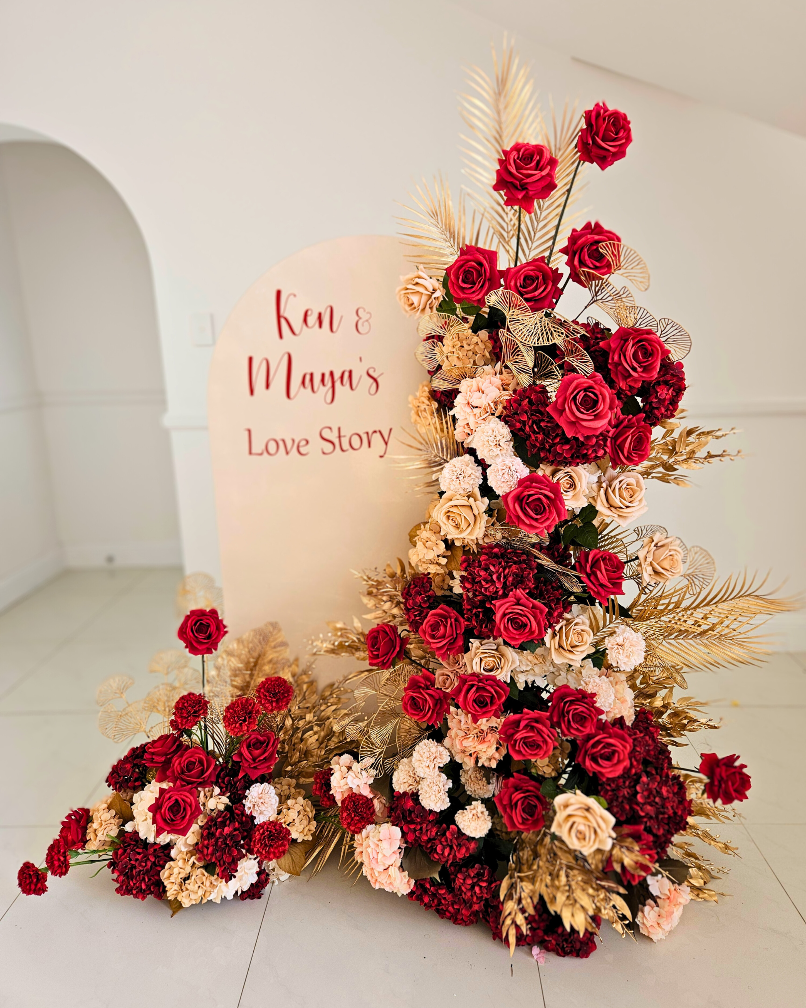 Floral backdrop in red, cream and gold. Signage says "Ken & Maya's Love Story". Balloon backdrop in white, green and gold, with green leaves immersed in the balloons. 5 safari animals and signage saying Wild Two. Prop hire, Prop hiring, Prop hire, event stylists Brisbane, brisbane event styling, brisbane event styling, event stylist Brisbane, Brisbane Wedding, Gold Coast Wedding, Floral Styling, Lush & Lavish Events, Brisbane Corporate Styling, Gold Coast Corporate Styling, Brisbane Brand Activation