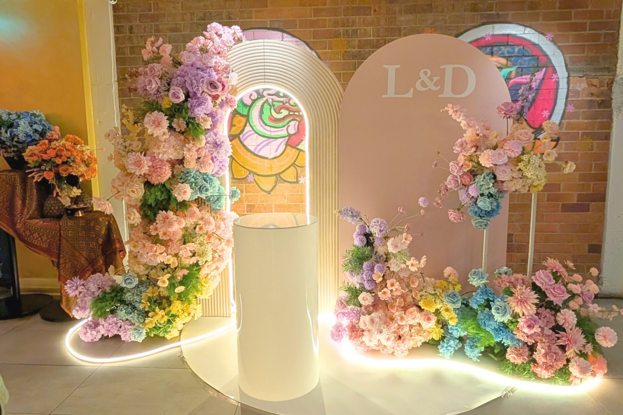 Pastel floral wedding backdrop styling for Linh and Dineel’s Brisbane wedding reception featuring organic floral arches, romantic arrangements and personalised L&D signage by Lush & Lavish Events
