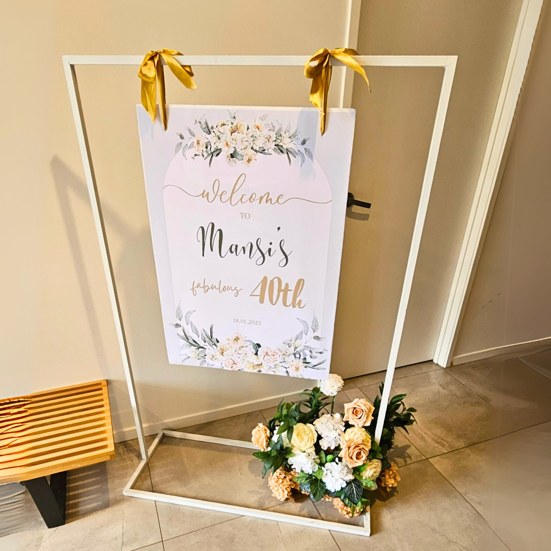 Large frame welcome sign hire featuring a personalised A4 poster displayed on a white metal frame with elegant ribbons and a complementary floral arrangement. Perfect for weddings, engagement parties, baby showers, milestone birthdays, 18th and 21st birthday celebrations, kids parties and luxury event styling in Brisbane, Gold Coast and South East Queensland.