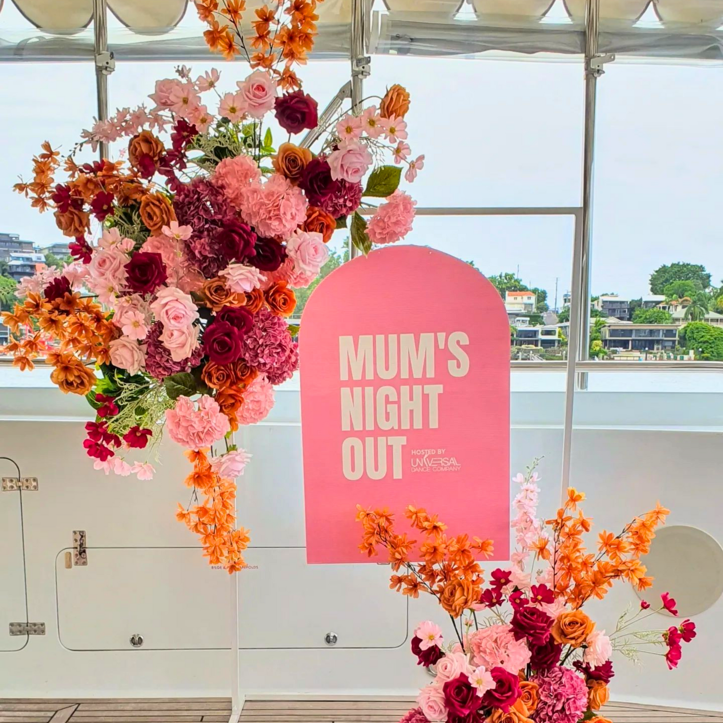Pink, orange, and yellow flowers with a sign reading 'MUM’S NIGHT OUT' against a clear sky. Prop hire, Prop hiring, Prop hire, event stylists Brisbane, brisbane event styling, brisbane event styling, event stylist Brisbane, Brisbane Wedding, Gold Coast Wedding, Floral Styling, Lush & Lavish Events, Brisbane Tablescape, Gold Coast Tablescapes, Brisbane Candle Hire
