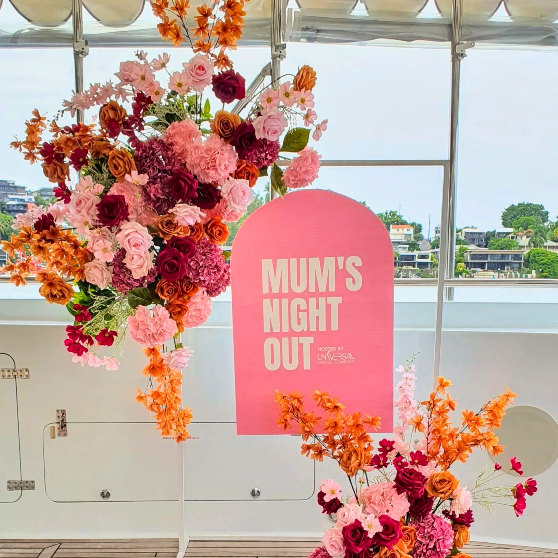 Pink, orange, and yellow flowers with a sign reading 'MUM’S NIGHT OUT' against a clear sky. Prop hire, Prop hiring, Prop hire, event stylists Brisbane, brisbane event styling, brisbane event styling, event stylist Brisbane, Brisbane Wedding, Gold Coast Wedding, Floral Styling, Lush & Lavish Events, Brisbane Tablescape, Gold Coast Tablescapes, Brisbane Candle Hire