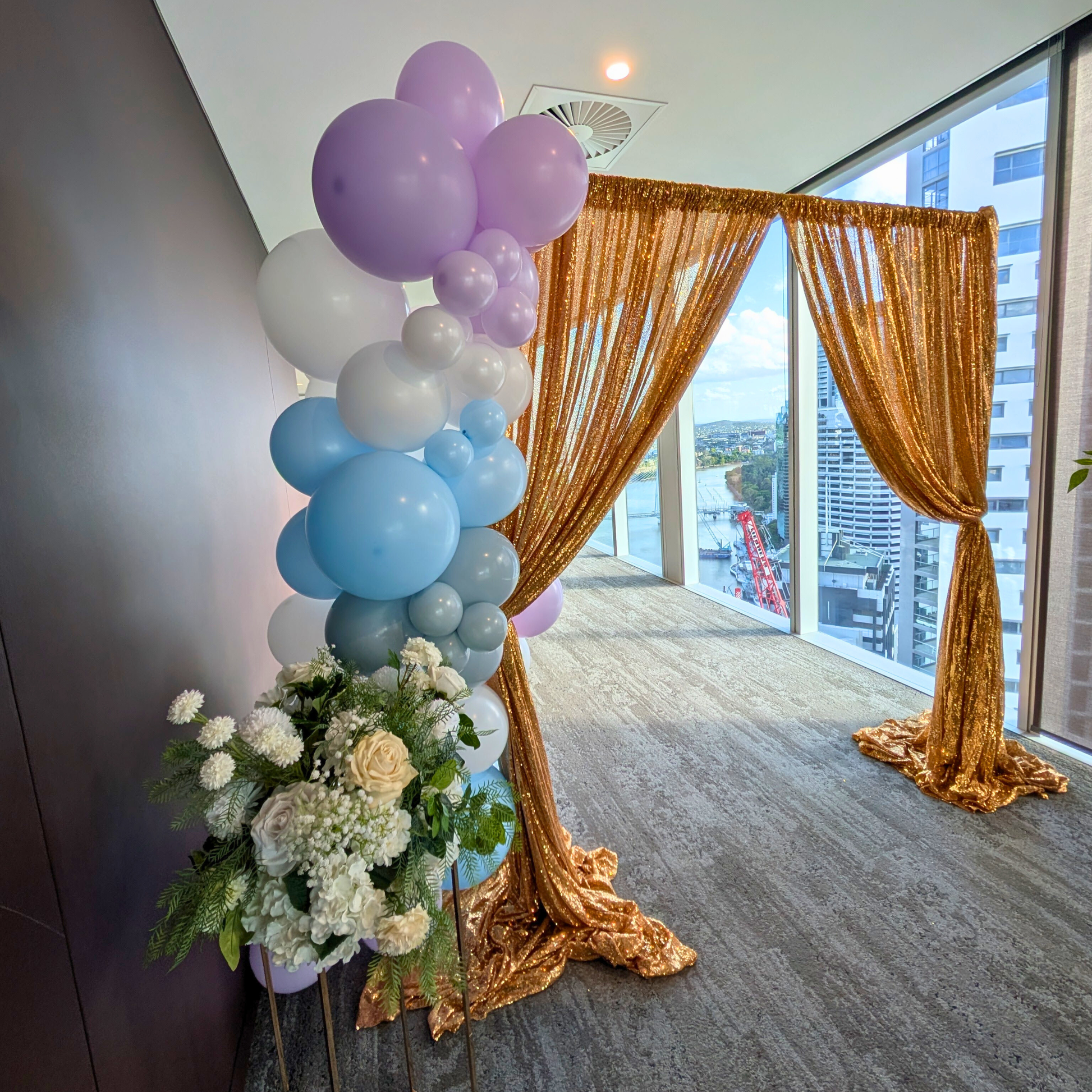Decorative setup with balloons and flowers in a room with large windows. Brisbane corporate event styling, Gold Coast corporate event styling, Brisbane brand activation styling, Gold Coast brand activation styling, Brisbane event entrance styling, Gold Coast event entrance styling, Brisbane balloon garland corporate, Gold Coast balloon garland corporate, Brisbane corporate event decor, Gold Coast corporate event decor, Brisbane conference styling, Gold Coast conference styling, Brisbane product launch styli