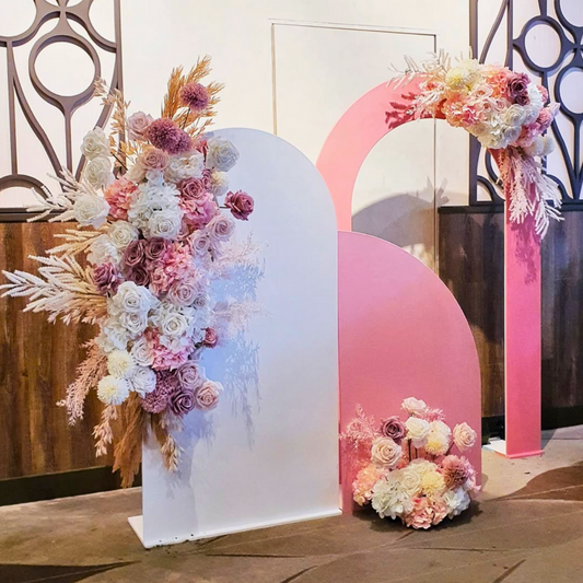 A pink and white floral engagement party backdrop featuring a large pink arch with floral arrangements, a white arch, and various decorative elements. Styled by Lush and Lavish Events in Brisbane.