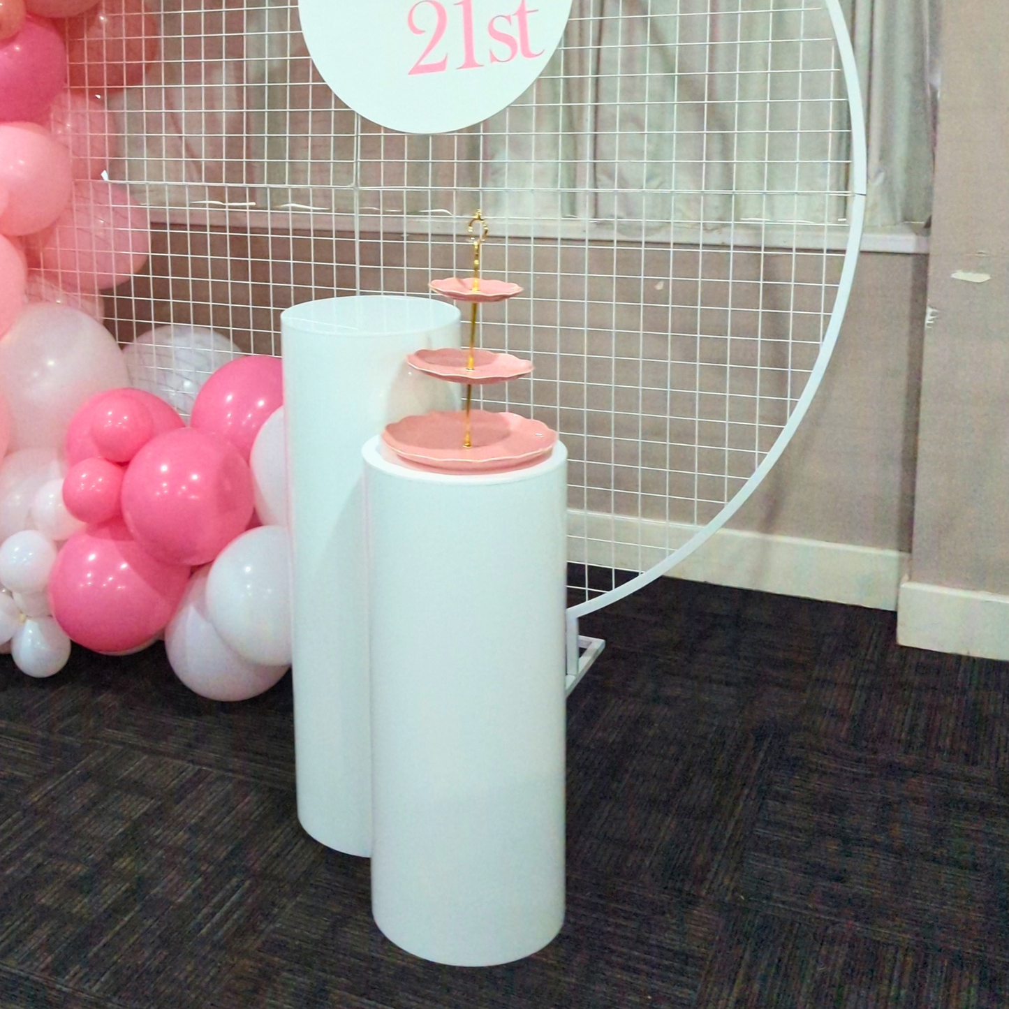 White cake stand with pink top against a wall with balloons and '21st' sign. pink cupcake stand hire, blue cupcake stand hire, 3 tier cupcake stand hire, cupcake stand hire brisbane, cupcake stand hire gold coast, kids party cupcake stand, birthday party dessert stand, baby shower cupcake stand, party decor hire qld, dessert table styling hire, colourful cupcake stand, party prop hire brisbane, party hire gold coast, kids birthday party decor, cupcake display stand hire, themed party decor hire, event styli