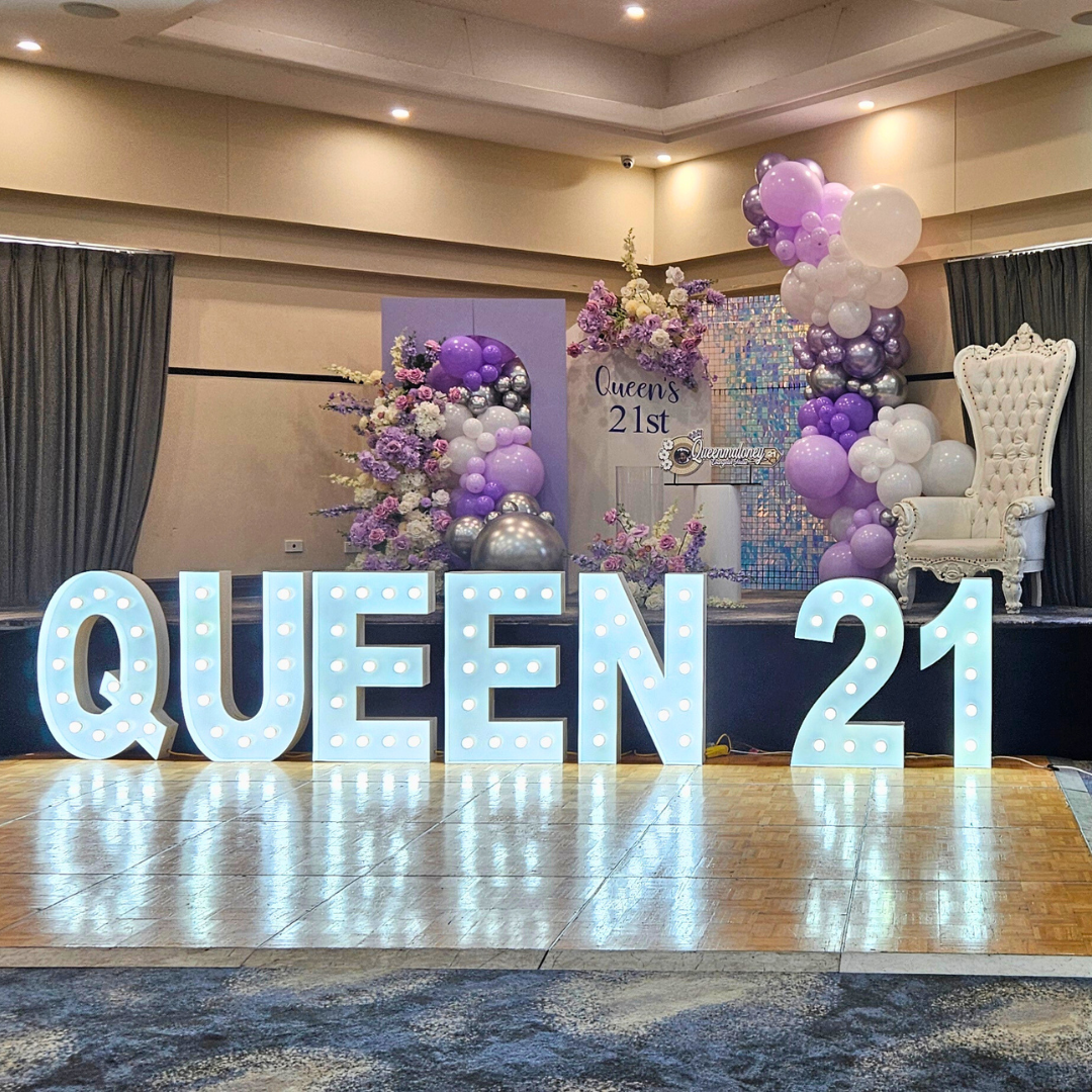 Balloon and floral backdrop in purples. silver and white. Signage says "Queen's 21st" and large LED lights. Prop hire, Prop hiring, Prop hire, event stylists Brisbane, brisbane event styling, brisbane event styling, event stylist Brisbane, Brisbane Wedding, Gold Coast Wedding, Floral Styling, Lush & Lavish Events, Brisbane Corporate Styling, Gold Coast Corporate Styling, Brisbane Brand Activation, Gold Coast Tablescapes, Brisbane Candle Hire