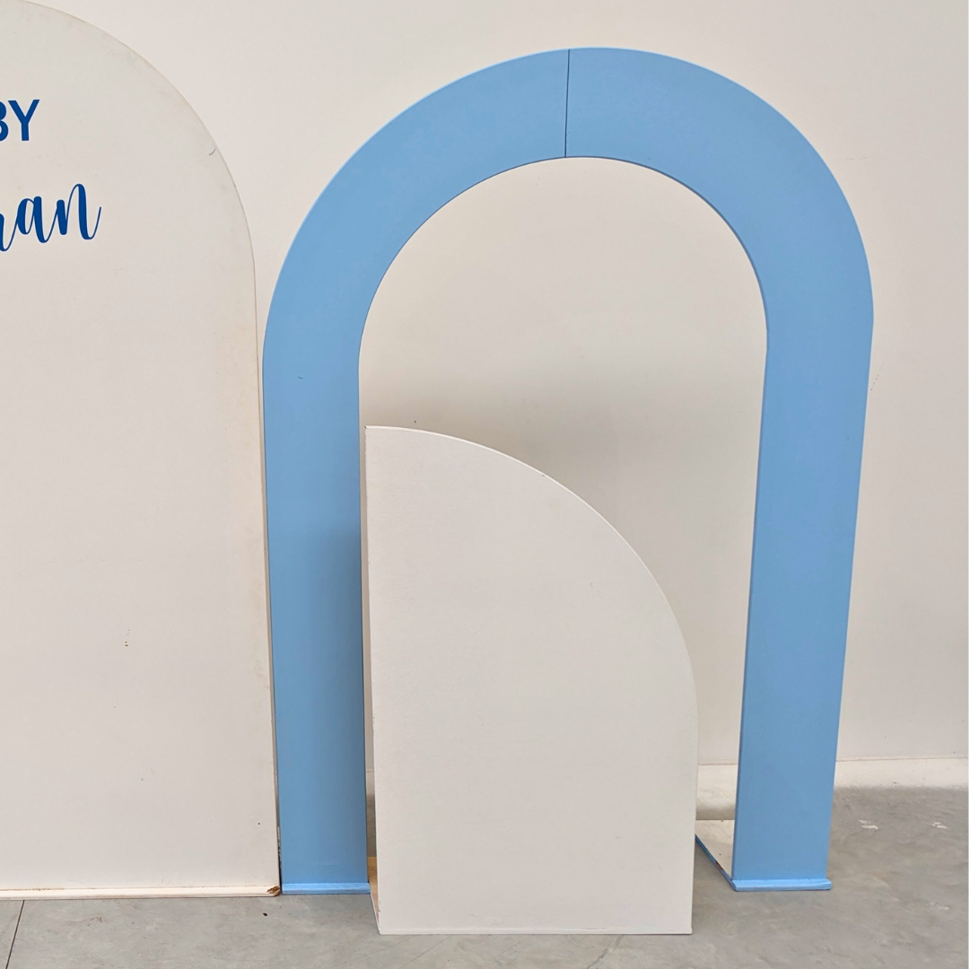 Blue and white arch-shaped product on a light gray floor with a white wall background. Prop hire, Prop hiring, Prop hire, event stylists Brisbane, brisbane event styling, brisbane event styling, event stylist Brisbane, Brisbane Wedding, Gold Coast Wedding, Floral Styling, Lush & Lavish Events, Brisbane Corporate Styling, Gold Coast Corporate Styling, Brisbane Brand Activation, Gold Coast Tablescapes, Brisbane Candle Hire