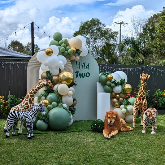 Balloon backdrop in white, green and gold, with green leaves immersed in the balloons. 5 safari animals and signage saying Wild Two. Prop hire, Prop hiring, Prop hire, event stylists Brisbane, brisbane event styling, brisbane event styling, event stylist Brisbane, Brisbane Wedding, Gold Coast Wedding, Floral Styling, Lush & Lavish Events, Brisbane Corporate Styling, Gold Coast Corporate Styling, Brisbane Brand Activation