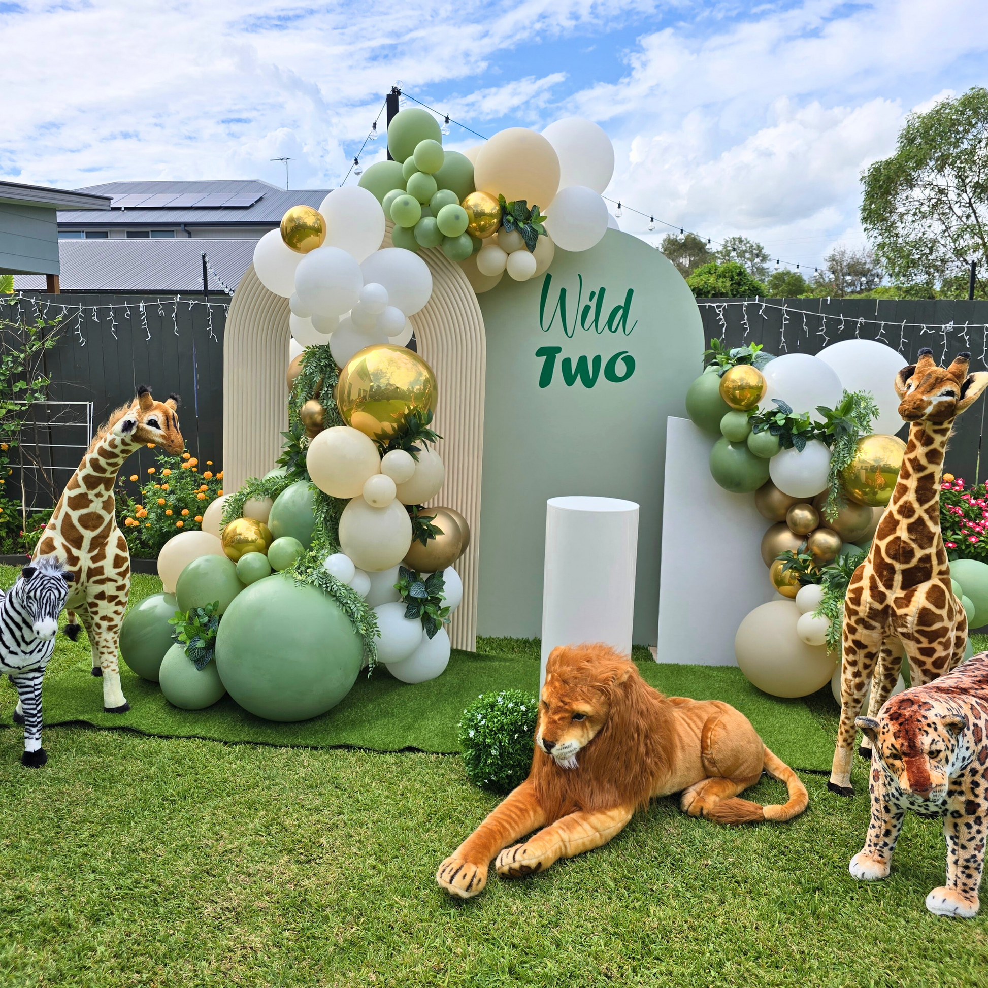 Balloon backdrop in white, green and gold, with green leaves immersed in the balloons. 5 safari animals and signage saying Wild Two. Prop hire, Prop hiring, Prop hire, event stylists Brisbane, brisbane event styling, brisbane event styling, event stylist Brisbane, Brisbane Wedding, Gold Coast Wedding, Floral Styling, Lush & Lavish Events, Brisbane Corporate Styling, Gold Coast Corporate Styling, Brisbane Brand Activation