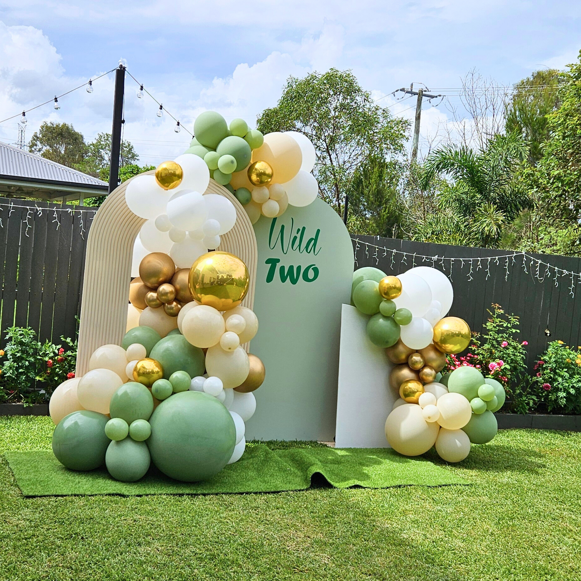 Balloon backdrop in white, green and gold, with green leaves immersed in the balloons. 5 safari animals and signage saying Wild Two. Prop hire, Prop hiring, Prop hire, event stylists Brisbane, brisbane event styling, brisbane event styling, event stylist Brisbane, Brisbane Wedding, Gold Coast Wedding, Floral Styling, Lush & Lavish Events, Brisbane Corporate Styling, Gold Coast Corporate Styling, Brisbane Brand Activation
