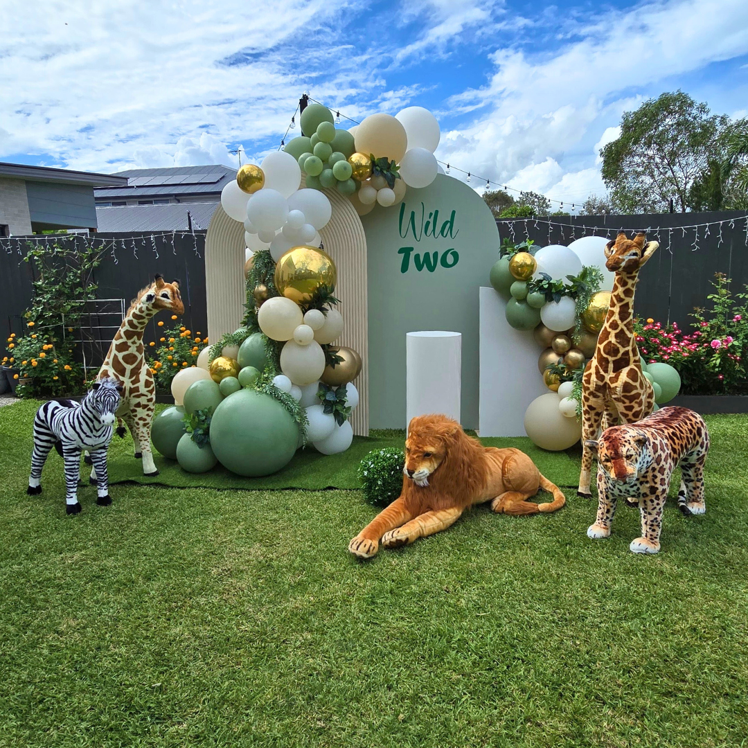 Balloon backdrop in greens, whites and gold with safari animals. Signage says "Wild Two" with greenery in the balloons. Prop hire, Prop hiring, Prop hire, event stylists Brisbane, brisbane event styling, brisbane event styling, event stylist Brisbane, Brisbane Wedding, Gold Coast Wedding, Floral Styling, Lush & Lavish Events, Brisbane Corporate Styling, Gold Coast Corporate Styling, Brisbane Brand Activation, Gold Coast Tablescapes, Brisbane Candle Hire